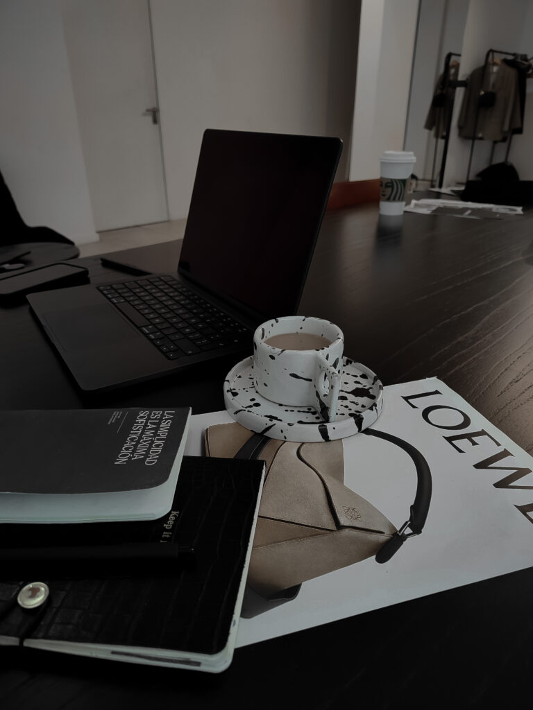 Laptop und verschiedene Magazine stehen auf Schreibtisch. Dunkler Farbfilter über gesamten Bild.